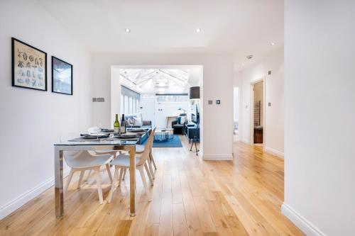 a dining room and living room with a table and chairs at 2 Bedr, 3 Beds, 2 Bath Covent Garden 3-min subway in London