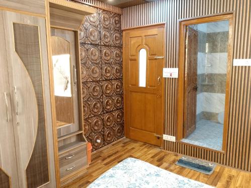 a room with a wooden door and a mirror at Dream Live Stay Inn in Srinagar