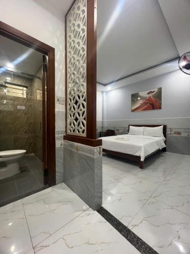 a bedroom with a bed and a shower and a sink at Thuật Nguyễn Hotel in Da Nang