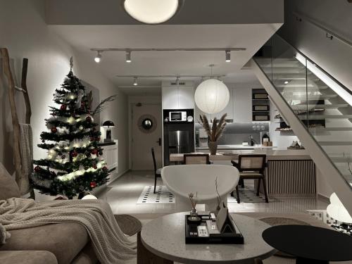 a living room with a christmas tree and a kitchen at Cozy Ins Duplex EkoCheras 1-6pax in Kuala Lumpur