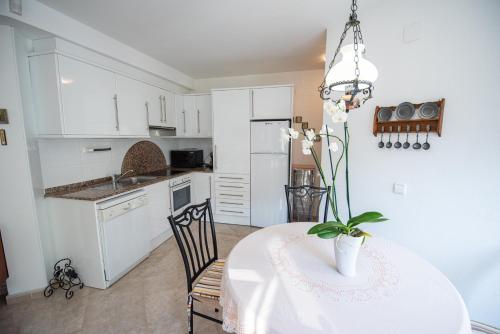 a kitchen with a table with a vase of flowers on it at Apartamento primera linea de mar in L'Ampolla