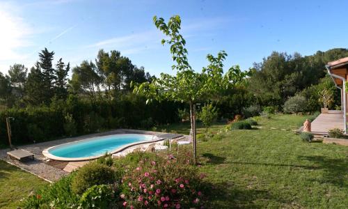 - une piscine dans une cour à côté d'un jardin dans l'établissement Gîte de l'Olympe, à Aspiran