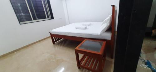 a bathroom with a white sink and a table at Guruprasad Home Stay in Kolhapur