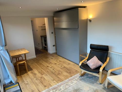 a living room with a chair and a table at Tiny house with pull down bed in Cottingham