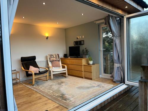 a living room with two chairs and a television at Tiny house with pull down bed in Cottingham
