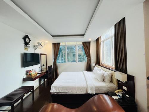 a bedroom with a bed and a television and a couch at A25 Hotel - 20 Bùi Thị Xuân in Ho Chi Minh City