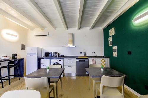 a kitchen with two tables and a green wall at Appartamento immerso nella natura con parcheggio - Primula in Sòis