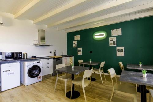 a kitchen with two tables and a green wall at Appartamento immerso nella natura con parcheggio - Primula in Sòis