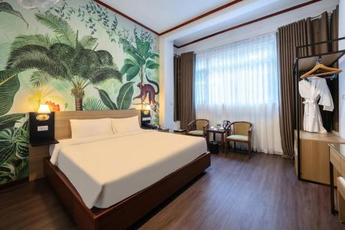 a bedroom with a large bed with a tropical wallpaper at A25 Hotel - 80 Mai Hắc Đế in Hanoi