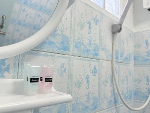 a bathroom with blue and white tiled walls at เทพกุญชร Budget-Friendly Room in Ban Lam Rua Taek