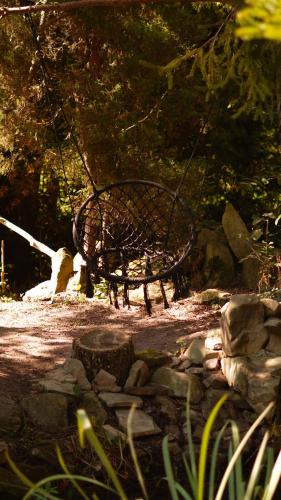 a swing seat in a park with rocks and trees at Гранд Алексік in Truskavets