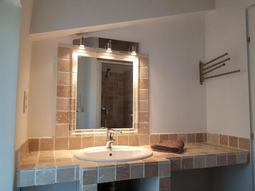 une salle de bain avec un lavabo et un miroir dans l'établissement Maison familiale sur la route du Ventoux, à Mormoiron