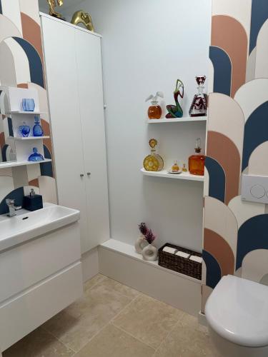 La salle de bains est pourvue d'un lavabo, de toilettes et d'étagères. dans l'établissement A deux pas d'Arras, à Arras