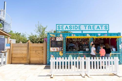 a seaside treats store with a white fence in front at Haven Golden Sands Immaculate 3 Bedroom Pet and Autism Friendly 6 Berth Caravan with Large Gated Veranda in Mablethorpe