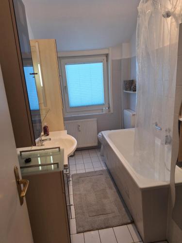 a bathroom with a tub and a sink at Villa Duli in Bad Harzburg