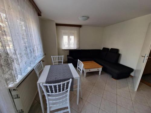 a living room with a black couch and a table at Wohnung - Goldene Gerste in Frankfurt/Main