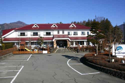 a large white building with a red roof at Kawaguchiko Lakeside Hotel in Fujikawaguchiko