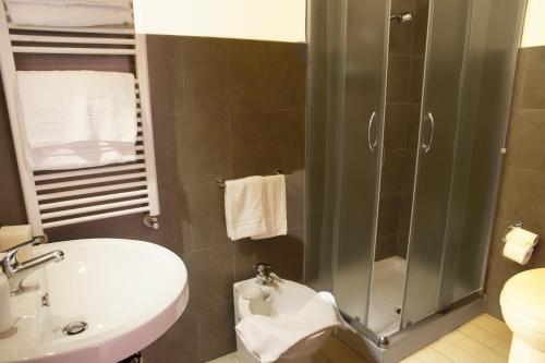 a bathroom with a shower and a sink and a toilet at Merulana Suite in Rome