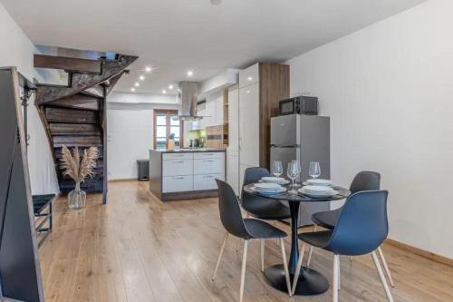une salle à manger avec une table et des chaises et une cuisine dans l'établissement Duplex le Vestige, à Metz
