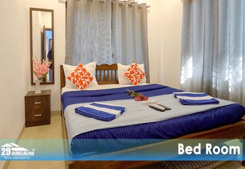 a bed with blue and white sheets and pillows at Rooms at sea dreamz in Alibag