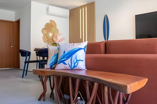 a living room with a couch and a coffee table at Villa Naluri - Seu Refúgio a 50 metros da praia em Japaratinga in Japaratinga