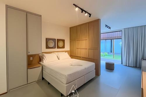 a bedroom with a bed and a large window at Villa Naluri - Seu Refúgio a 50 metros da praia em Japaratinga in Japaratinga
