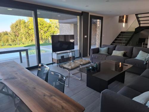 a living room with a couch and a table at Chalet de lujo con piscina cercano a la playa in Nigrán