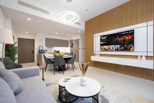 un soggiorno con un divano e una TV a parete di EMAAR GRANDE - Elegant 1 Bedroom Apartment - Infinity Pool - 1min to Dubai Mall and Burj Khalifa a Dubai