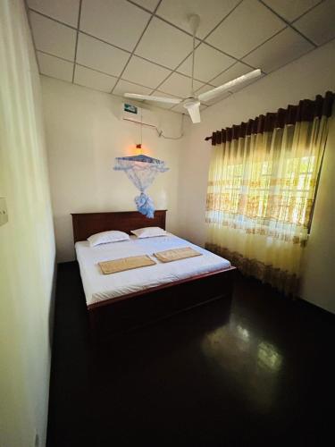 a bedroom with a bed and a lamp in it at Rashini Villa in Beruwala