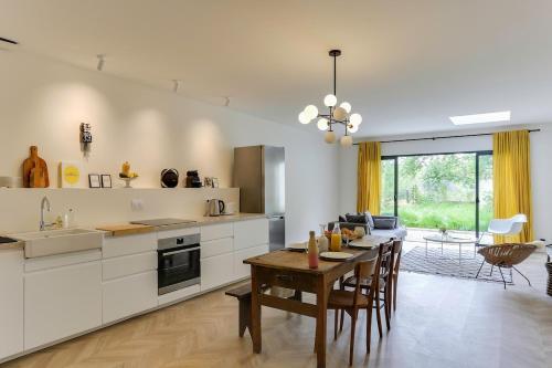 une cuisine avec une table et une salle à manger dans l'établissement Maison Joseph - Chambre 2, à Saint-Jacques-de-la-Lande