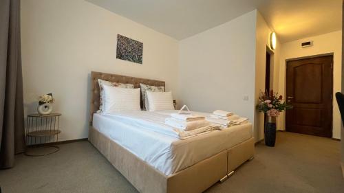 a bedroom with a bed with towels on it at Europa Ocna Mures in Ocna-Mureşului