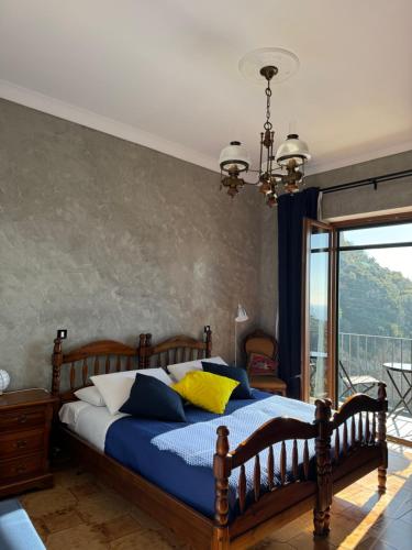 a bedroom with a bed with blue and yellow pillows at Voce del Mare Apartment in Pontone