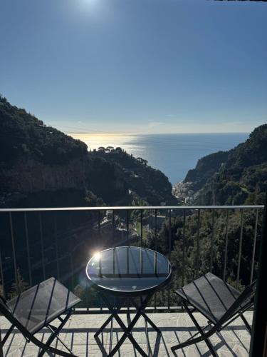 a table and chairs on a balcony with the ocean at Voce del Mare Apartment in Pontone
