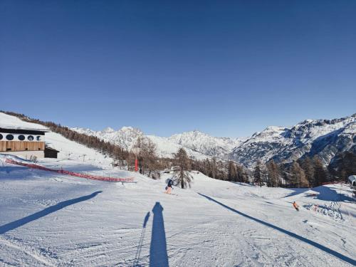 a shadow of a person on a snow covered ski slope at "La bâtisse des prés" in Puy-Saint-Vincent