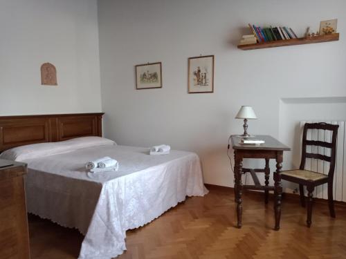 Un dormitorio con una cama, una silla y una mesa. en Casa La Sughera, Lamporecchio, Vinci, en Fornello