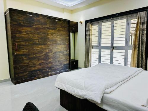 a bedroom with a large wooden wall at kokan kinara by wild flower in Pune