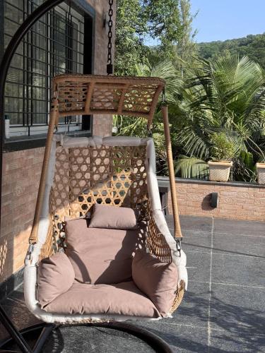 a swinging chair with a giraffe on a patio at kokan kinara by wild flower in Pune