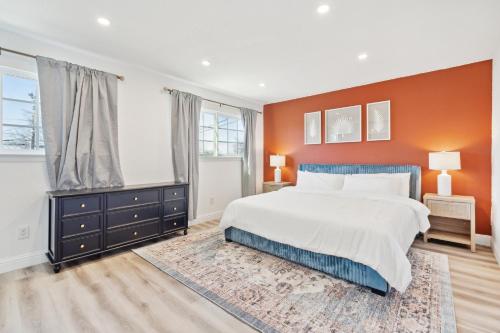 a bedroom with a large bed and an orange wall at Cozy Home with Hot Tub - Family-Friendly Yard home in Livermore