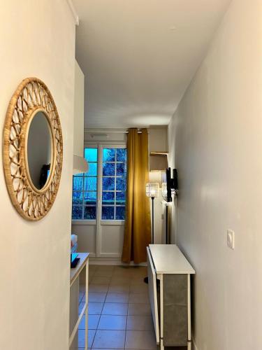 Cette chambre comprend un miroir, une table et une fenêtre. dans l'établissement Charmant Studio avec extérieur, à Trouville-sur-Mer