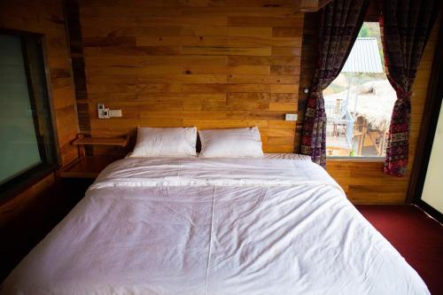 a large bed in a room with a window at Mây home Trạm Tấu bungalow in Ya Ló