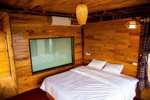 a bedroom with a flat screen tv and a bed at Mây home Trạm Tấu bungalow in Ya Ló