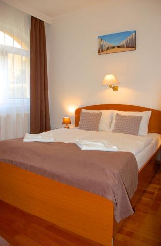 a large bed in a room with a window at 4 You Apartmans in Egerszalók