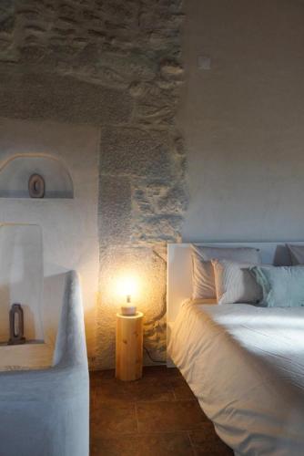 a bedroom with two beds and a light on the wall at Charming Douro Valley Stone Home in Coura