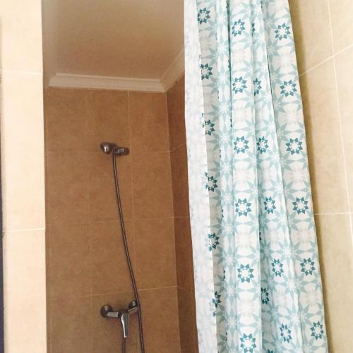 a shower with a shower curtain in a bathroom at Alcudia Smir in Fnidek