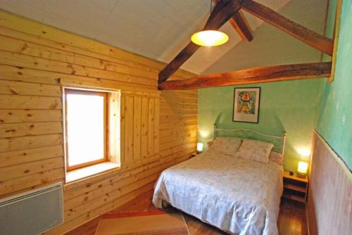 a bedroom with a bed in a wooden room at Le Coin des Hortensias in La Puye