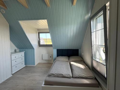 a small bedroom with a bed in a attic at Słowiński Horyzont in Rowy