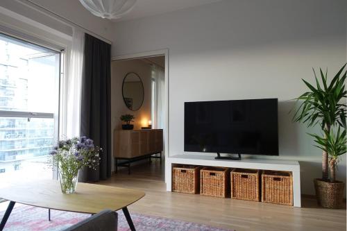 a living room with a flat screen tv on a wall at Modern 1BR with Huge Balcony Above Mall of Tripla in Helsinki