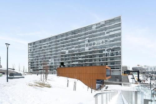 a large building with snow in front of it at Modern 1BR with Huge Balcony Above Mall of Tripla in Helsinki