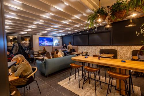 a restaurant with people sitting at tables and a bar at Boutique Macchiato Rooms in Novi Sad