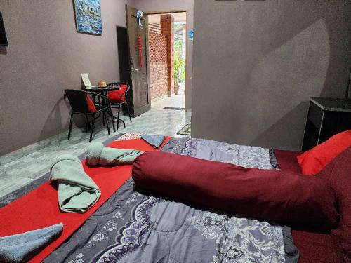 a bed in a room with a red blanket at Inspire Rooms Langkawi in Pantai Cenang